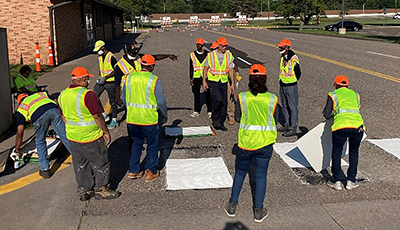 Photo: Pavement striping trainees painting a crosswalk.